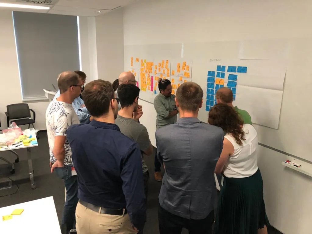 IBM workshop attendees gather around me as I facilitate co-creation sessions.